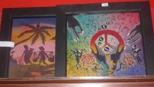 A pair of brightly coloured silkwork batik pictures in black frames