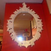 A French looking glass in white painted leafy frame