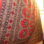 A Persian hand knotted carpet the rouge ground with motifs in multi running border