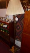 A brass Corinthian column form standard lamp raised on a step down square base on lion paw feet