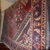 A fine North West Persian Bokhara rug with central medallion on a terracotta field within stylised