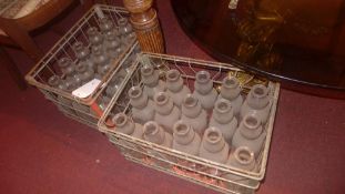 Two 1950s wire milk crates with fifteen original milk bottles in each