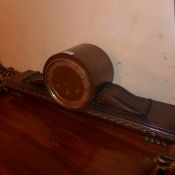 A 1930's walnut mantel clock with gadrooned detail raised on carved supports