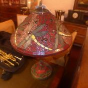 A Tiffany style lamp with leaded stained glass shade decorated with dragonflies