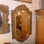 A C19th wall mirror of cartouche form with ornate gilded ribbon decoration