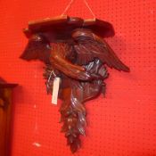 A black forest style wall bracket in the form of a carved eagle on a branch