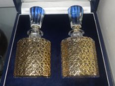 A cased pair of Garrard silver gilt and crystal decanters designed by Cal Howard