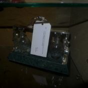 A silver plated and green marble tantalus with three cut glass decanters and stoppers