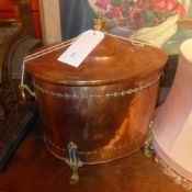A Victorian oval copper coal bucket with brass handles and feet