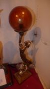 An Art Deco style table lamp in the form of a maiden including spherical glass shade