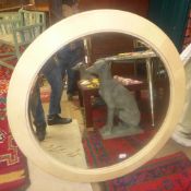 A large oval shagreen wall mirror with bevelled plate