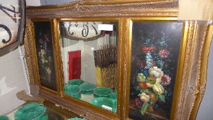 A gilted overmantel mirror flanked by floral panels