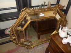A French style gilded wall mirror with segmented border and central bevelled plate