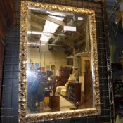 A silvered carved wall mirror with bevelled plate