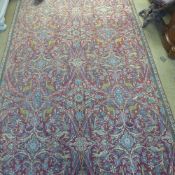 An extremely fine central Persian Varamin rug repeating floral and bird motifs on a rouge field with