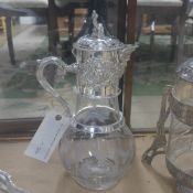 A large silver plated claret jug with grape decoration