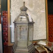 A large glass and verdigree metal hanging storm lanterns