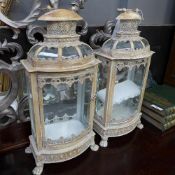 A pair of distressed wrought iron lanterns