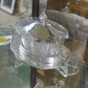 A silver plated glass butter dish on stand with lid