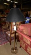 A brass standard lamp with matching shad