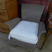 A Lloyd Loom design armchair with cushio