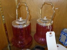 A pair of glass cranberry biscuit barrel