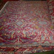 An extremely fine central Persian Varamin rug repeating floral and bird motifs on a rouge field with