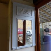 A white painted mirror with cherub decor