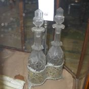 A silver plated cut glass three bottle T
