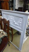 A white painted mirror with cherub decor