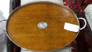 An Edwardian oak oval tray silver plated pierced gallery and carrying handles