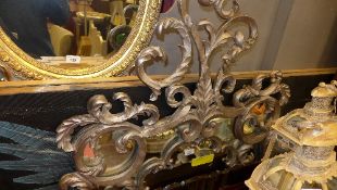 A wall mirror the shaped plate with carved silver foliate frame