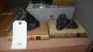 A pair of classical paperweight on book supports