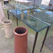 A wrought iron console table with glass top