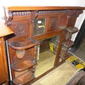 A late Victorian walnut overmantel mirror with carved panels and segmented mirror inset
