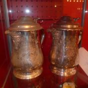 A pair of silver plated tankards with engraved floral detail