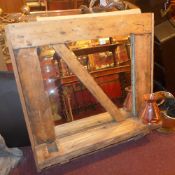 A rustic pine framed wall mirror with shelf