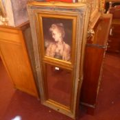 A gilt framed wall mirror with bevelled plate and inset image of a girl