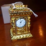 A gilt metal miniature carriage clock with bevelled glass panels