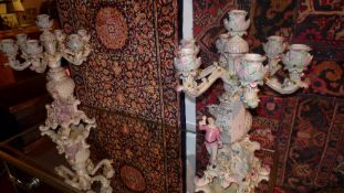 A large pair of Meissen style seven branch candelabra with figures and flower encrusted detail
