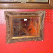 A Victorian looking glass with bevelled plate with velour clad cushion border and gilt frame