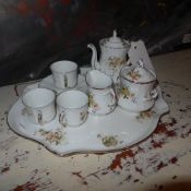 A Limoges porcelain tea set on a cartouche form tray decorated with flowers