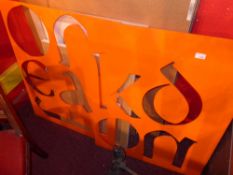 A pair of large orange plastic oversized stencils