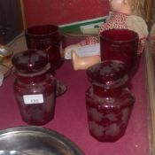A pair of ruby glass jars with covers (A/F) and two similar goblets