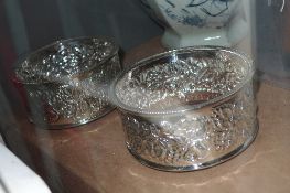 A pair of silver plated coasters with embossed detail