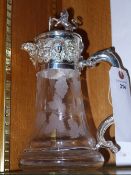 A silver plated embossed claret jug with lion lid