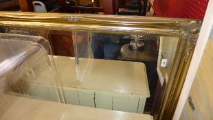 A wall mirror the rectangular bevelled plate within gilded frame