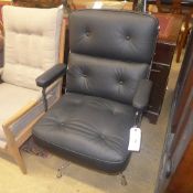 A Charles Eames style swivel desk chair upholstered in black leather on chromium supports