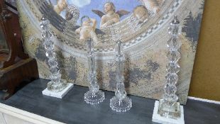 A set of four cut glass table lamps on marble and glass base