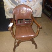 A Frederick Tiberman chair with studded brown leather and gilt eagle on the frame